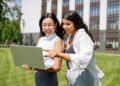 Women Looking at the Screen of a Laptop | FintechZoom