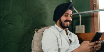 Happy Indian man with smartphone | IBOMMA TV